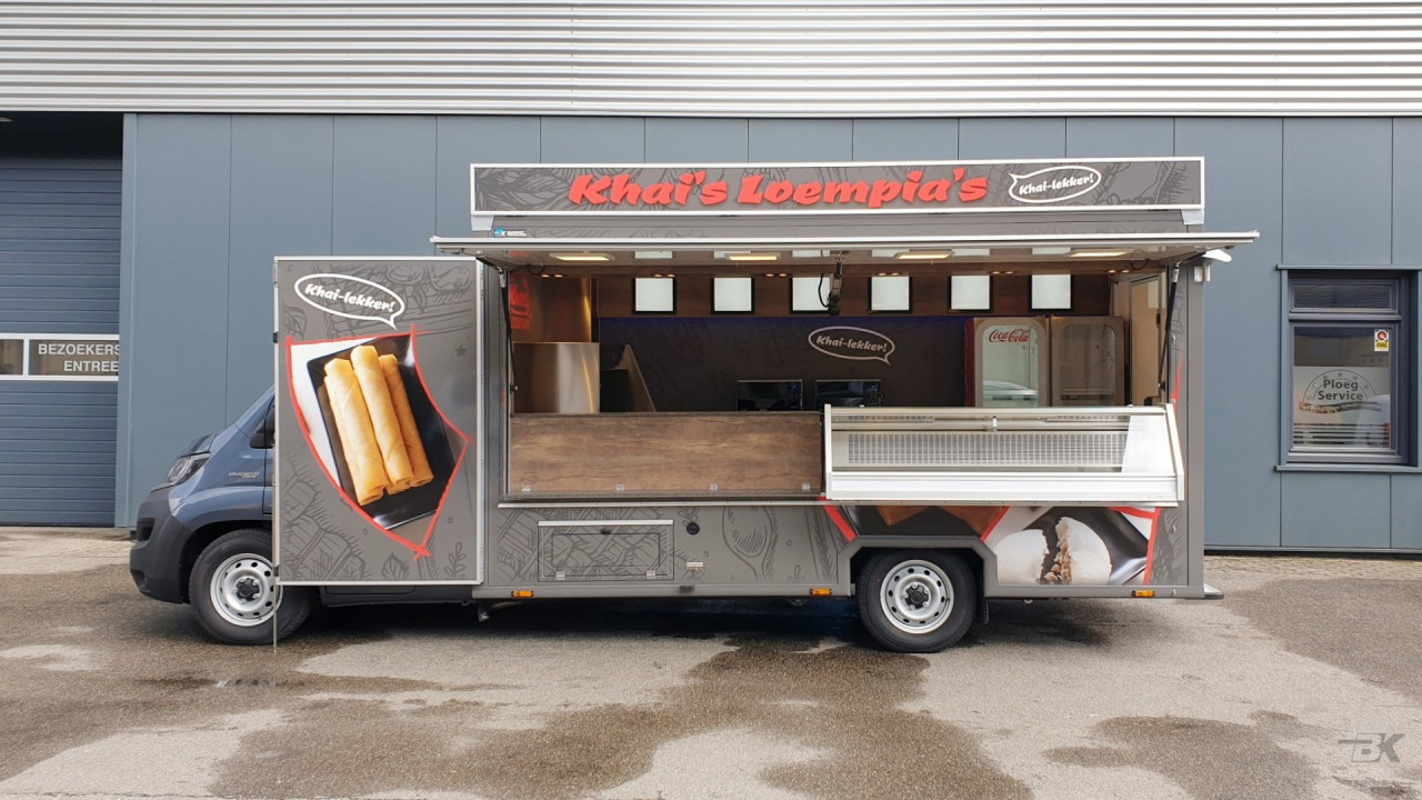 Zijaanzicht van een verkoopwagen voor loempia's met geopende luifel