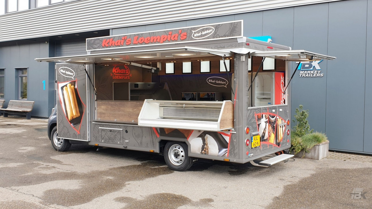 Zijaanzicht van een verkoopwagen voor loempia's met geopende luifel