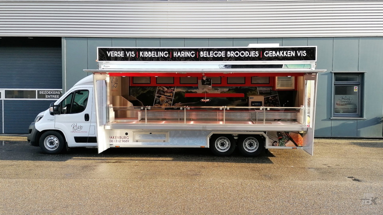 Zijaanzicht van een verkoopwagen voor vis met geopende luifel en zijborden