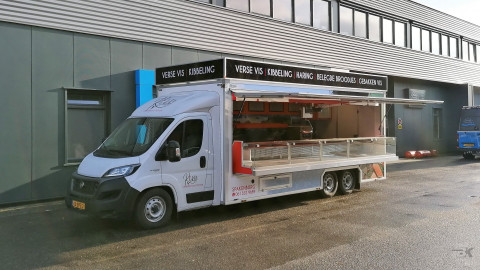 Zijaanzicht van een verkoopwagen voor vis met geopende luifel