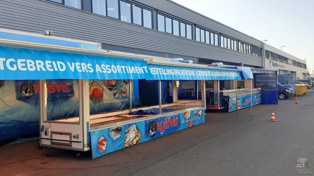 Zijaanzicht van twee aanhangwagens voor vis met geopende luifels