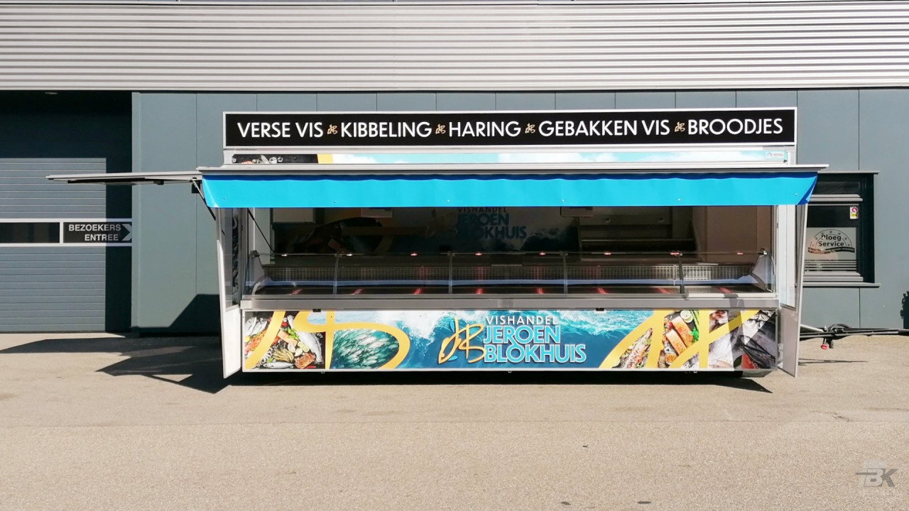 Zijaanzicht van een aanhangwagen voor vis met gesloten luifel en zijborden