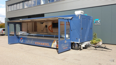 Zijaanzicht van een aanhangwagen voor vis met geopende luifel en zijborden
