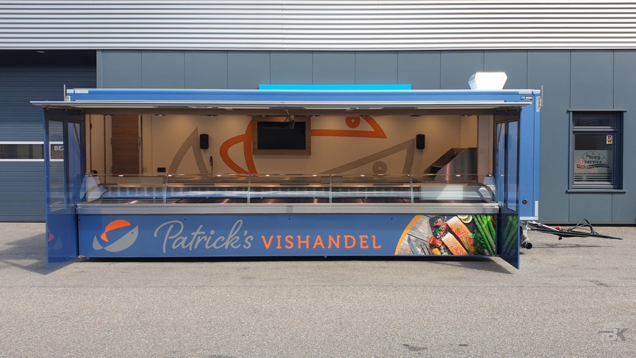 Zijaanzicht van een aanhangwagen voor vis met geopende luifel en zijborden