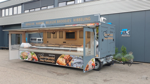 Zijaanzicht van een aanhangwagen voor vis met geopende luifel en zijborden