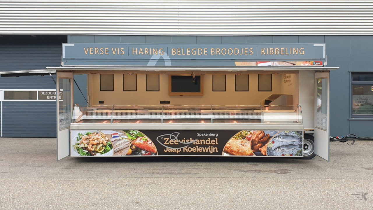 Zijaanzicht van een aanhangwagen voor vis met geopende luifel en zijborden