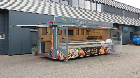Zijaanzicht van een aanhangwagen voor vis met geopende luifel en zijborden
