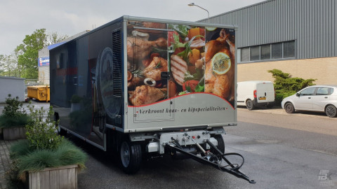 Vooraanzicht van een aanhangwagen voor kaas en kipspecialiteiten