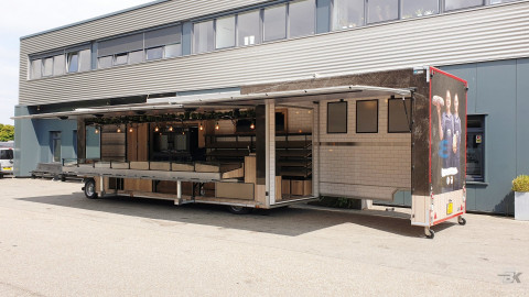 Zijaanzicht van een uitschuifbare aanhangwagen voor brood en banket met geopende luifel