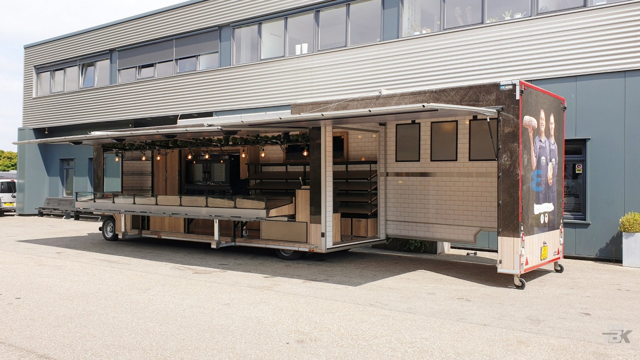 Zijaanzicht van een uitschuifbare aanhangwagen voor brood en banket met geopende luifel