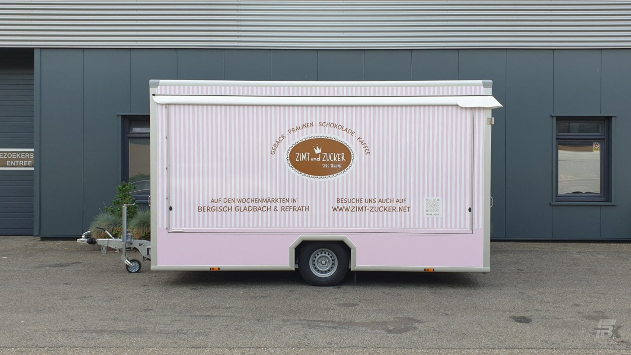Zijaanzicht van een aanhangwagen voor gebak, chocolade en koffie met gesloten luifel