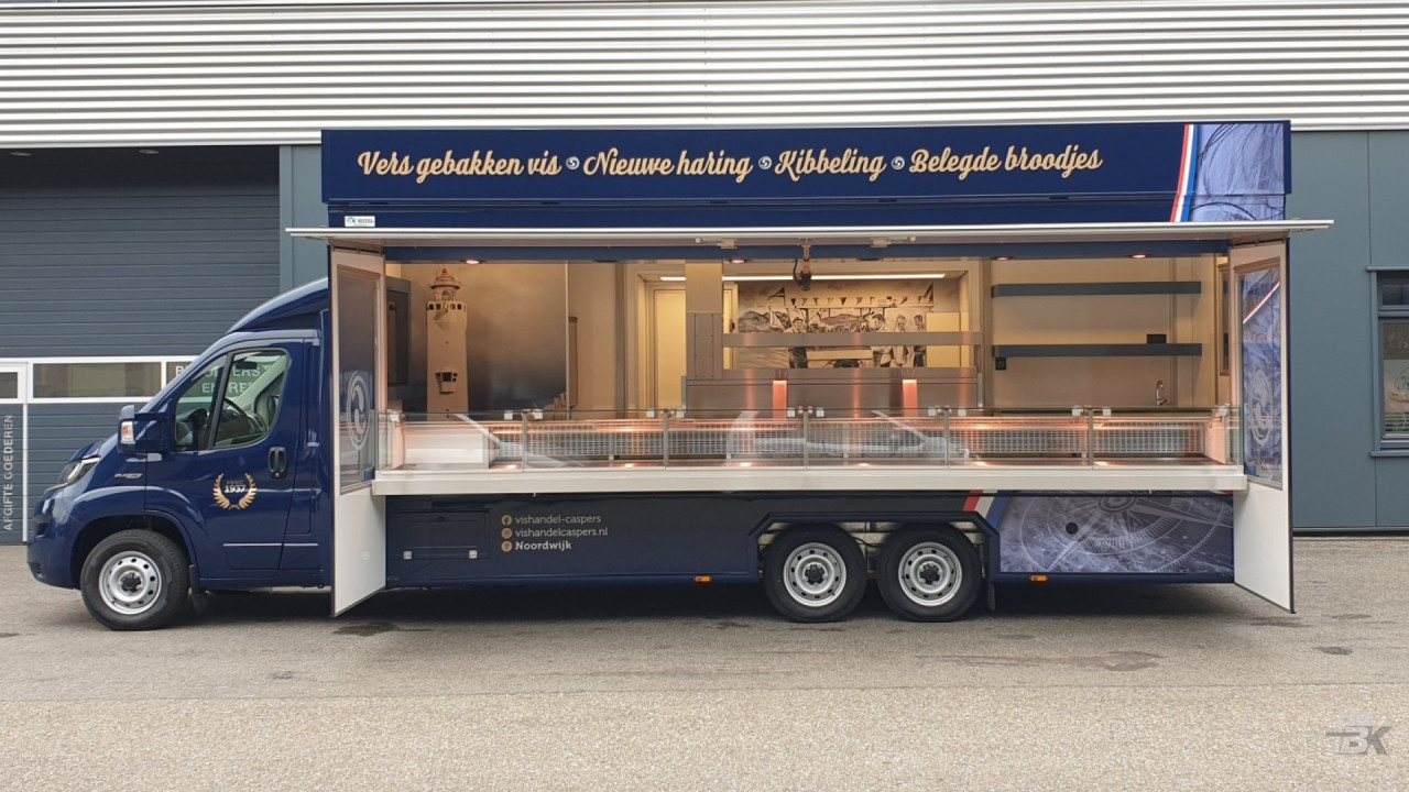 Zijaanzicht van een verkoopwagen voor vis met geopende luifel en zijborden