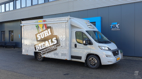Zijaanzicht van een verkoopwagen voor maaltijden met gesloten luifel
