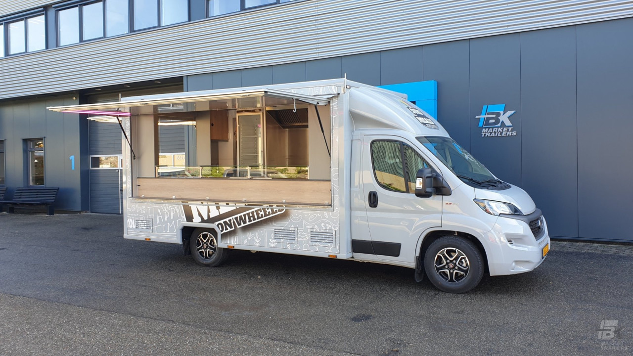 Zijaanzicht van een verkoopwagen voor maaltijden met geopende luifel