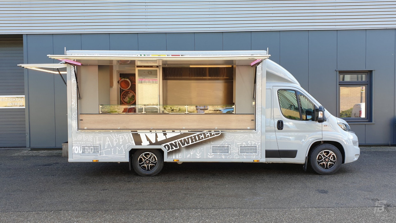 Zijaanzicht van een verkoopwagen voor maaltijden met geopende luifel