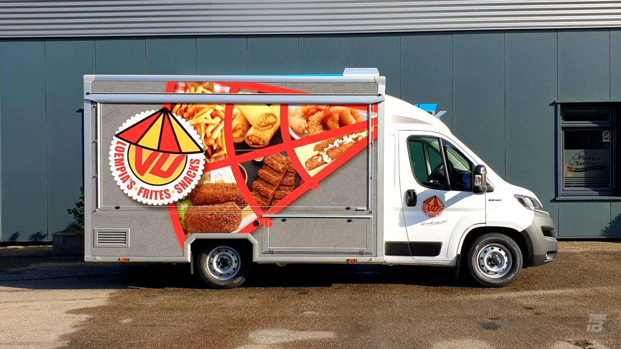 Zijaanzicht van een verkoopwagen voor loempia's, patat en snacks met gesloten luifel