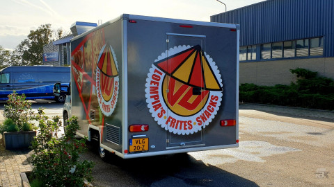 Achteraanzicht van een verkoopwagen voor loempia's, patat en snacks