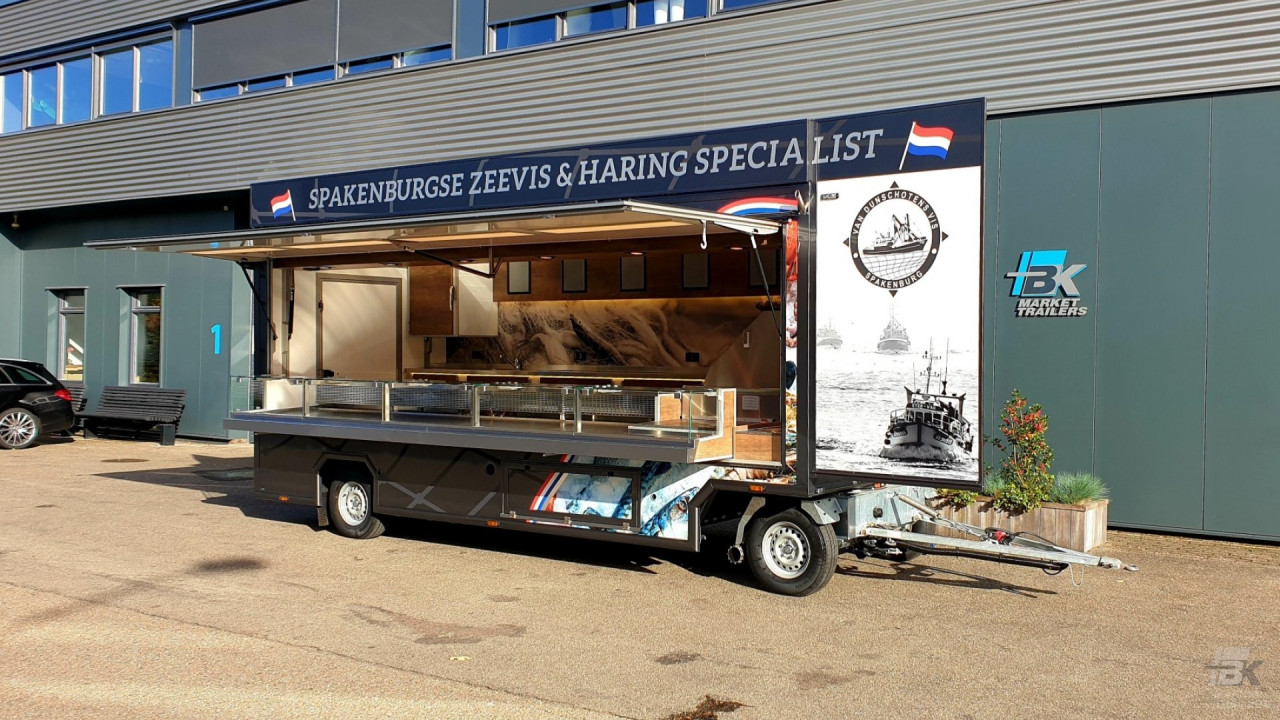 Zijaanzicht van een aanhangwagen voor vis met geopende luifel en zijbord