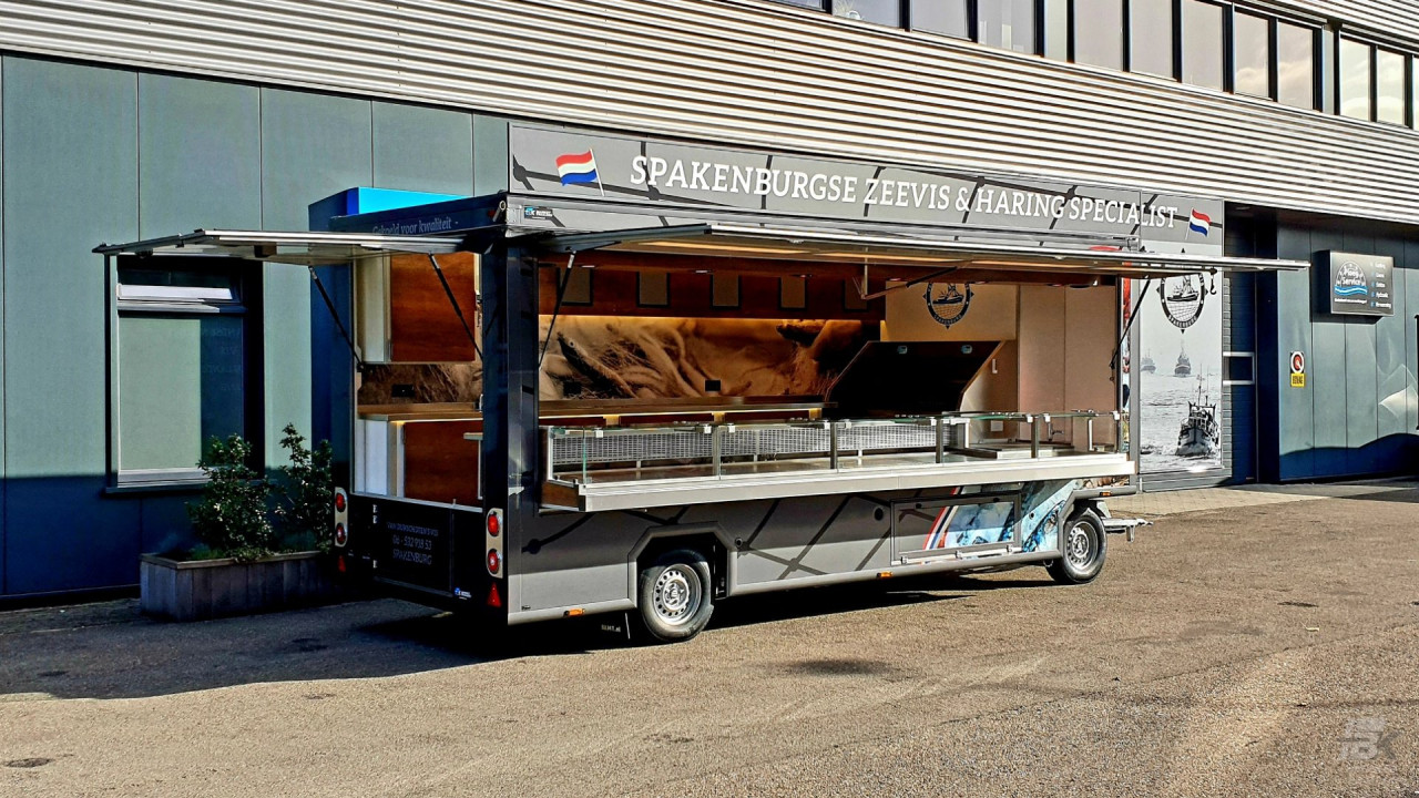 Zijaanzicht van een aanhangwagen voor vis met geopende luifel en zijbord
