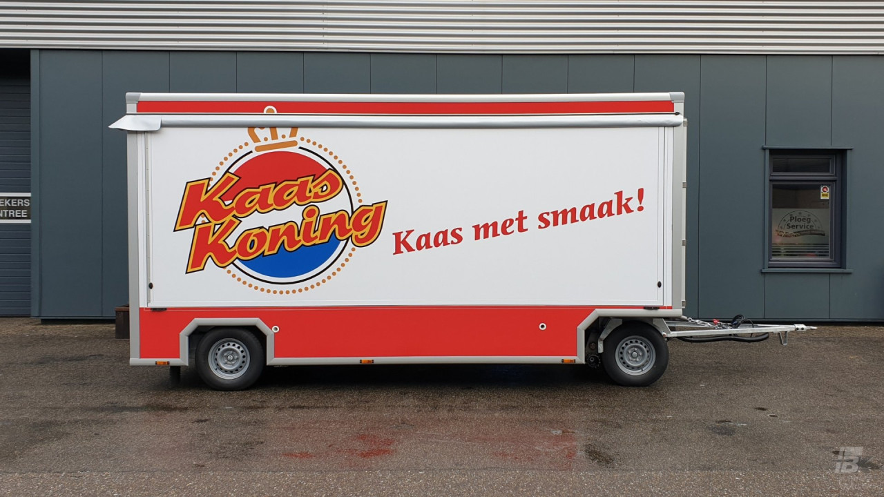 Zijaanzicht van een aanhangwagen voor kaas met gesloten luifel