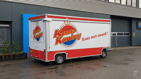 Zijaanzicht van een aanhangwagen voor kaas met gesloten luifel