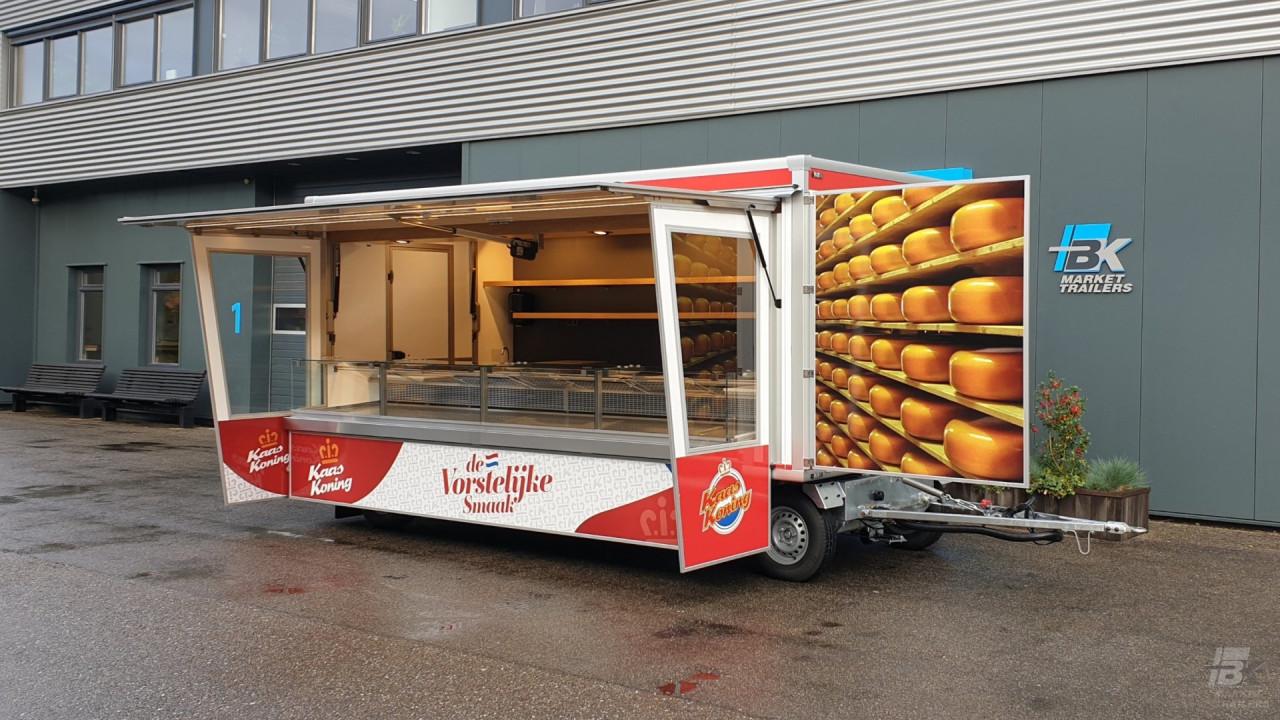 Zijaanzicht van een aanhangwagen voor kaas met geopende luifel