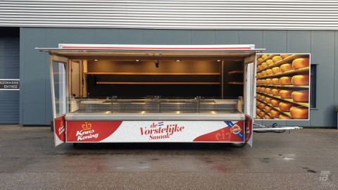 Zijaanzicht van een aanhangwagen voor kaas met geopende luifel