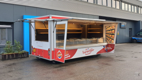 Zijaanzicht van een aanhangwagen voor kaas met geopende luifel