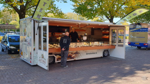 Volledig uitgestalde aanhangwagen voor noten, op een parkeerterrein