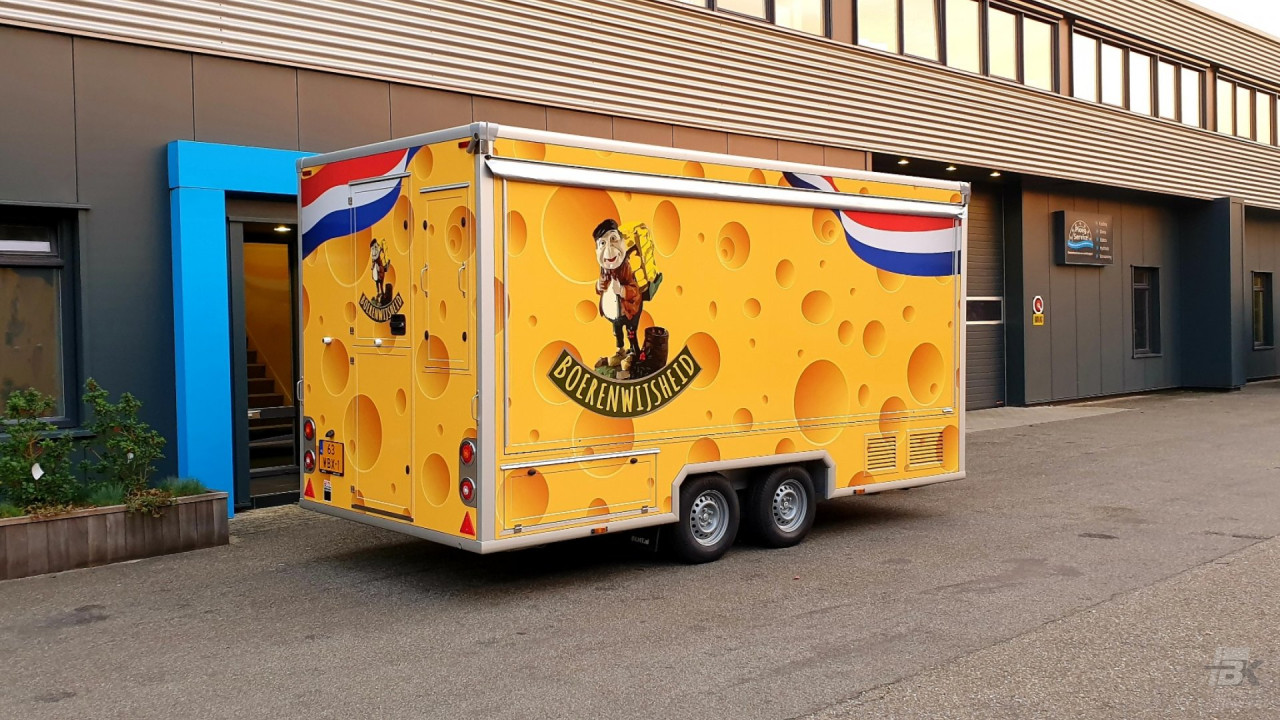 Zijaanzicht van een aanhangwagen voor kaas met gesloten luifel