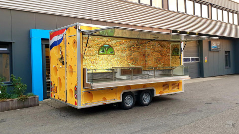 Zijaanzicht van een aanhangwagen voor kaas met geopende luifel