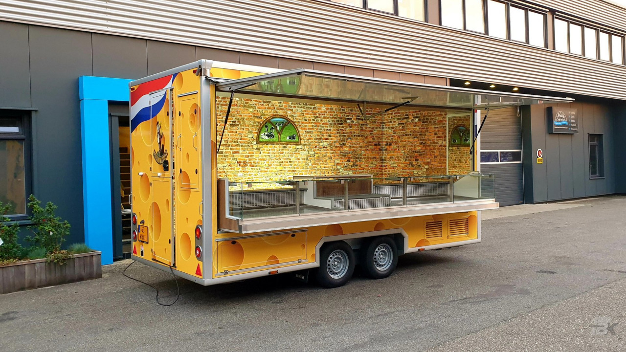 Zijaanzicht van een aanhangwagen voor kaas met geopende luifel
