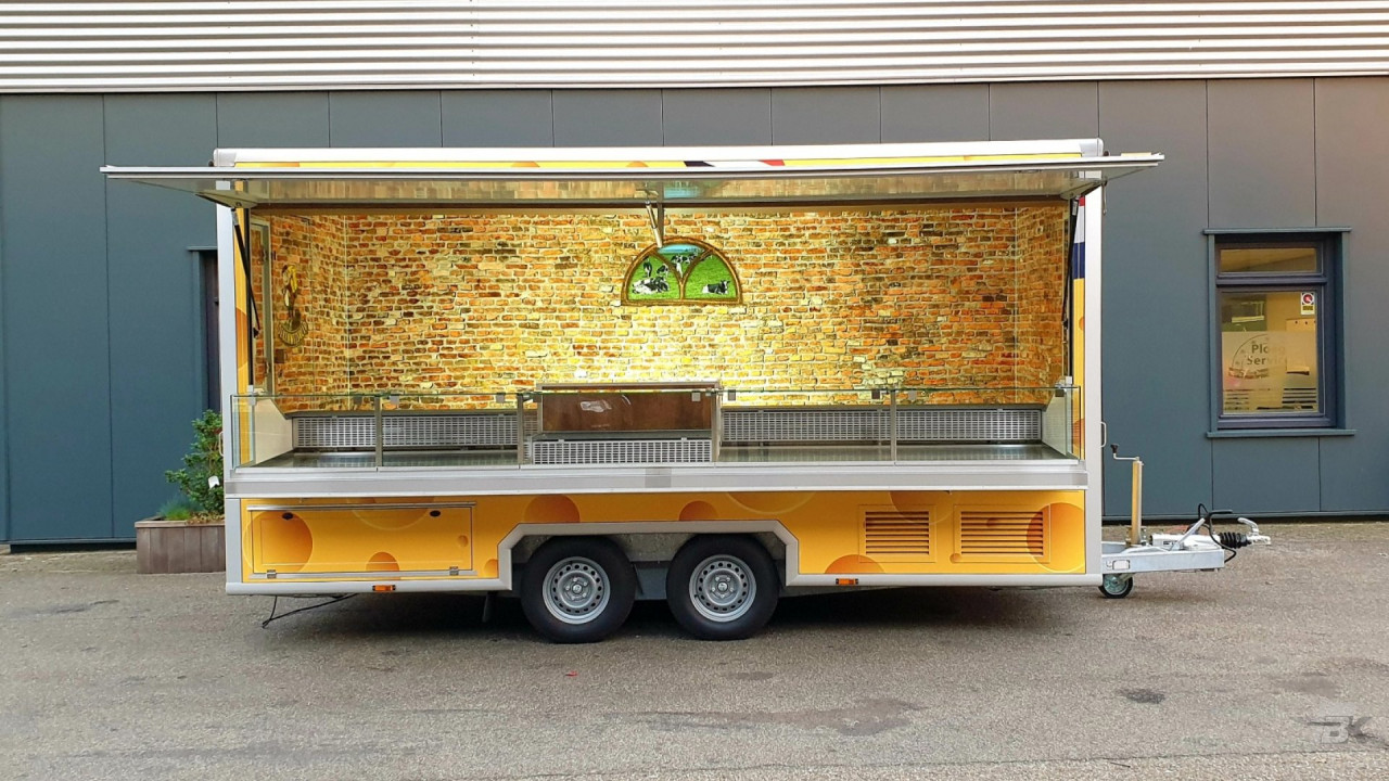 Zijaanzicht van een aanhangwagen voor kaas met geopende luifel