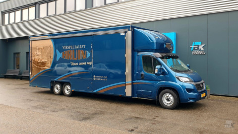 Zijaanzicht van een verkoopwagen voor vis met gesloten luifel