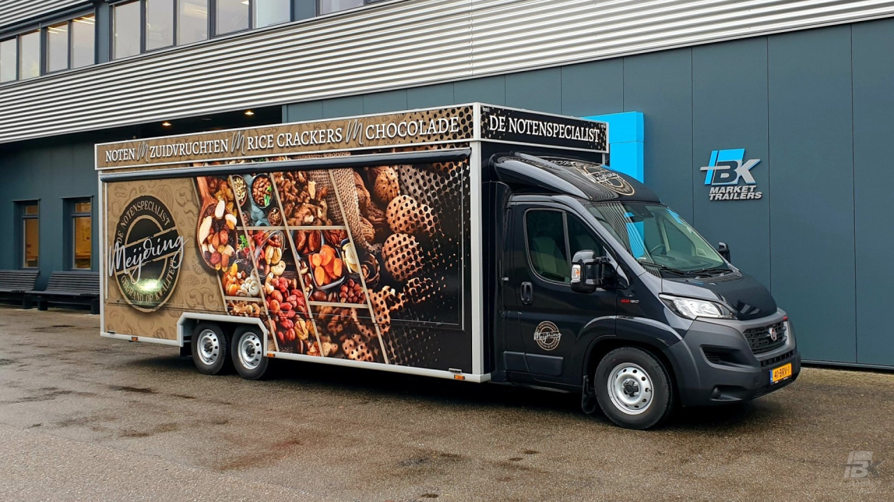 Zijaanzicht van een verkoopwagen voor noten met gesloten luifel