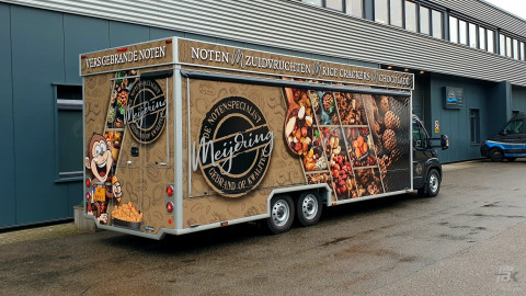 Zijaanzicht van een verkoopwagen voor noten met gesloten luifel