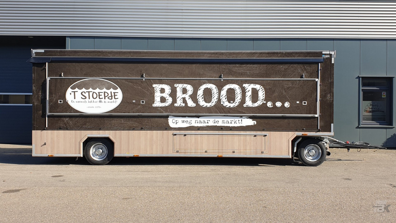 Zijaanzicht van een aanhangwagen voor brood en banket met gesloten luifel