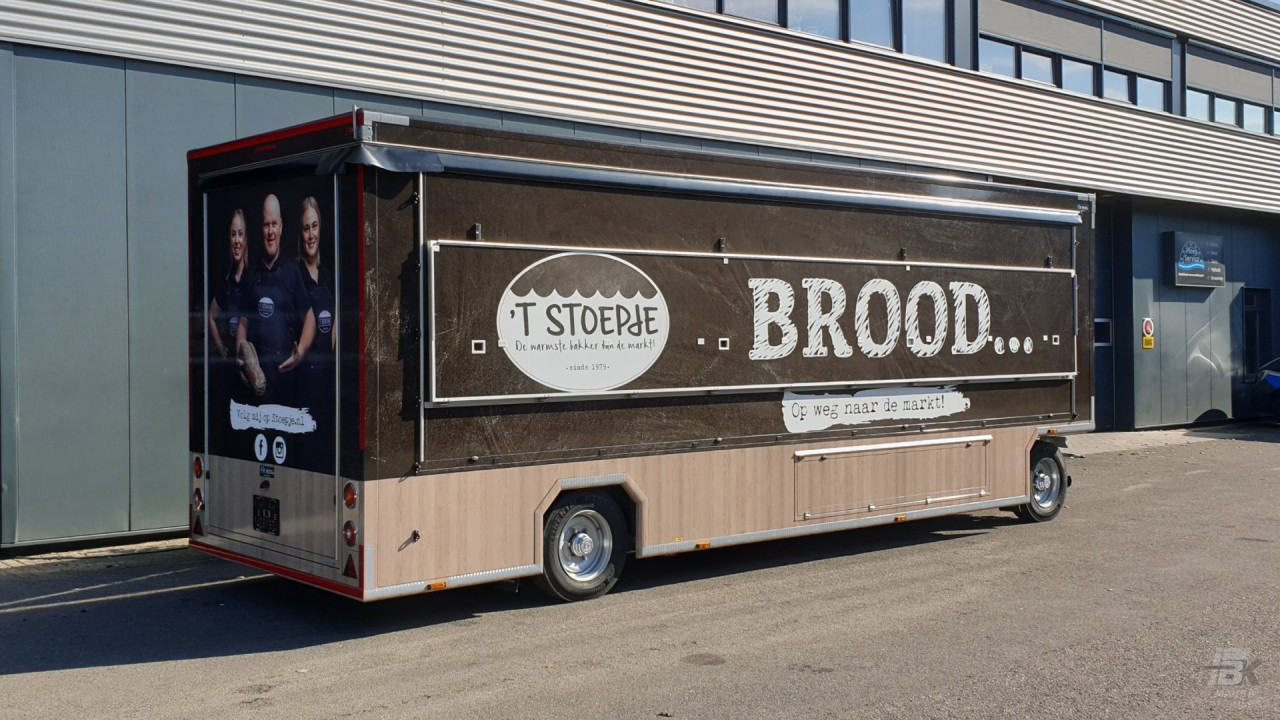 Zijaanzicht van een aanhangwagen voor brood en banket met gesloten luifel