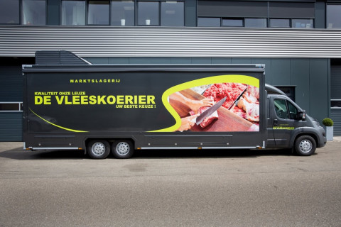 Zijaanzicht van een verkoopwagen voor vlees met gesloten luifel