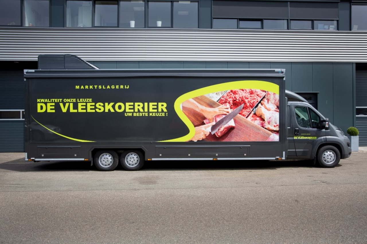 Zijaanzicht van een verkoopwagen voor vlees met gesloten luifel