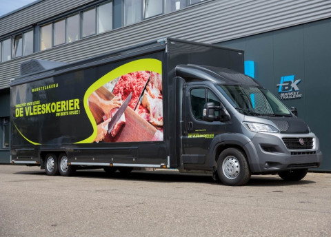 Zijaanzicht van een verkoopwagen voor vlees met gesloten luifel
