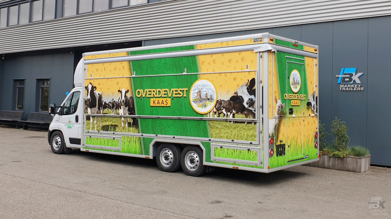 Zijaanzicht van een verkoopwagen voor kaas met gesloten luifel