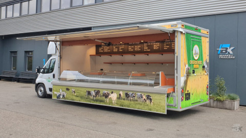 Zijaanzicht van een verkoopwagen voor kaas met geopende luifel