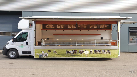 Zijaanzicht van een verkoopwagen voor kaas met geopende luifel