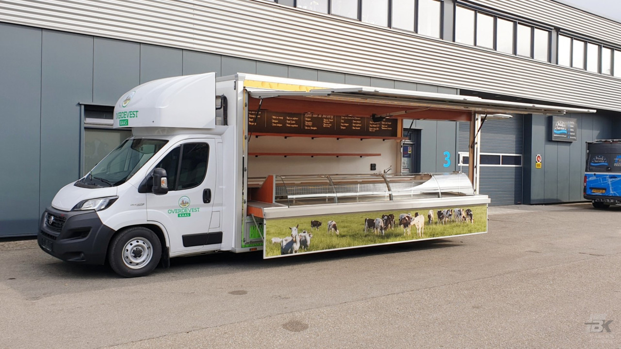 Zijaanzicht van een verkoopwagen voor kaas met geopende luifel