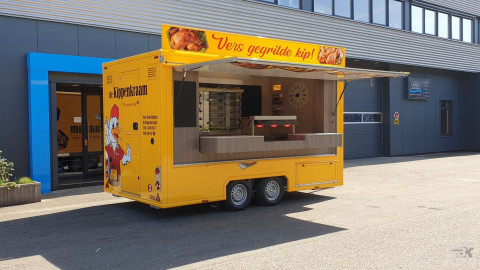 Zijaanzicht van een aanhangwagen voor kip met geopende luifel