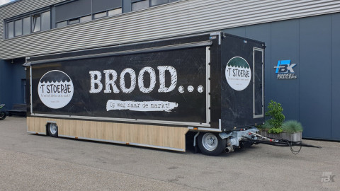 Zijaanzicht van een aanhangwagen voor brood en banket met gesloten luifel