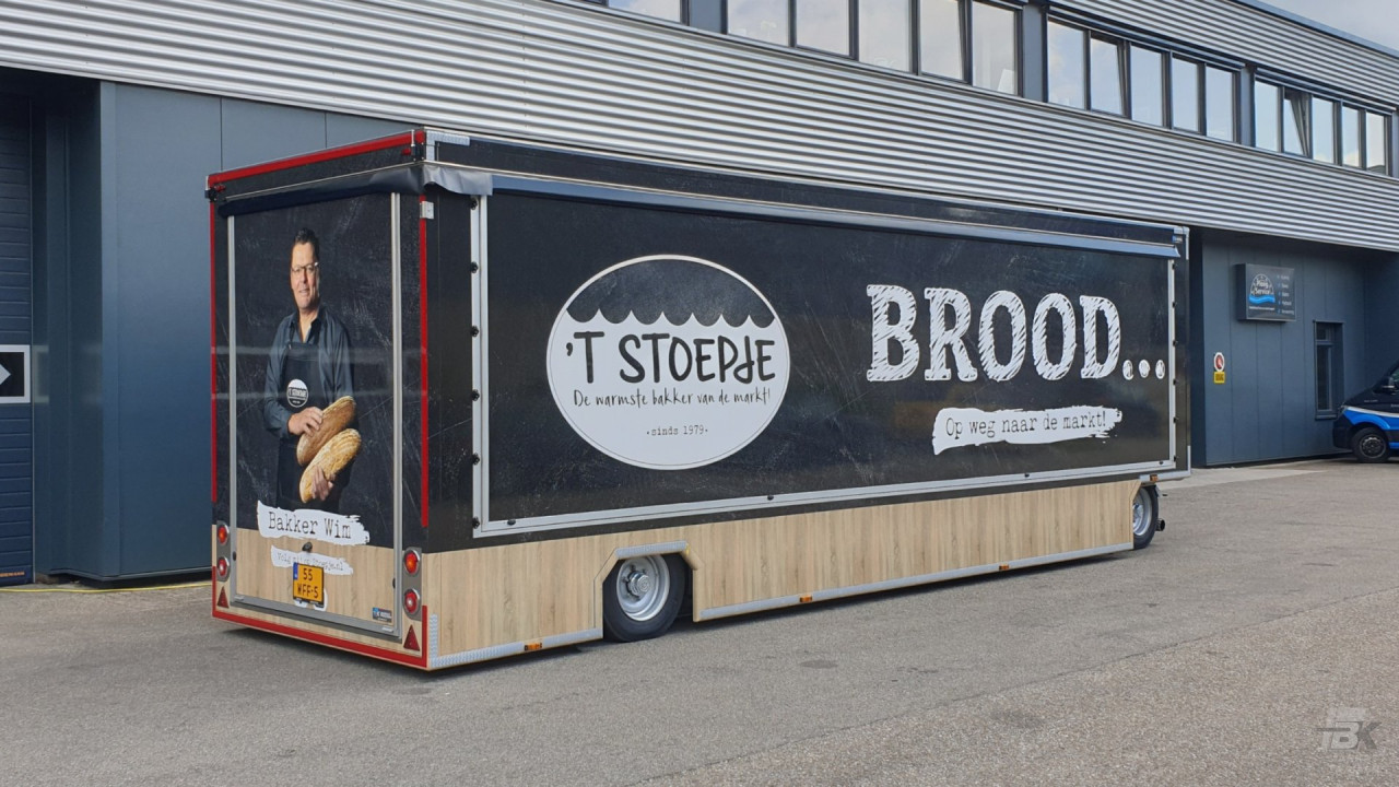 Zijaanzicht van een aanhangwagen voor brood en banket met gesloten luifel