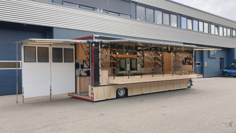 Zijaanzicht van een aanhangwagen voor brood en banket met geopende luifel