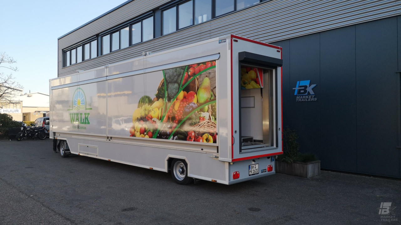 Zijaanzicht van een uitschuifbare aanhangwagen voor groente en fruit met gesloten luifel